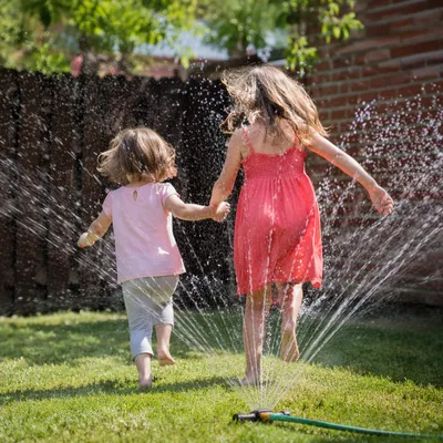 Joyful Children Running Through Summer Sprinkler