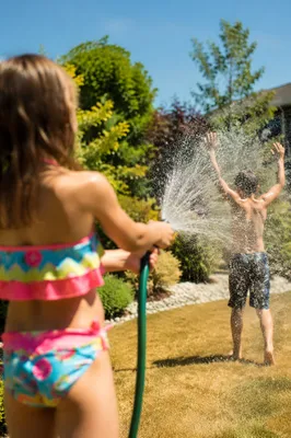Children Playing in Summer Sprinkler Backyard