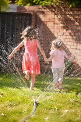 Joyful Children Running Through Summer Sprinkler