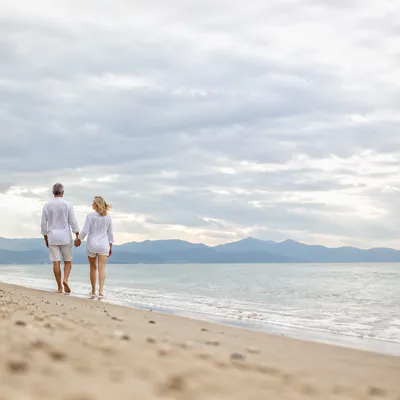 Mature Couple Walking Hand in Hand on Beach