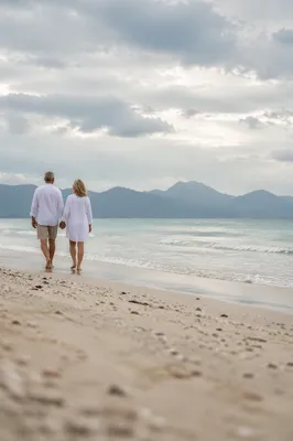 Mature Couple Walking Hand in Hand on Beach