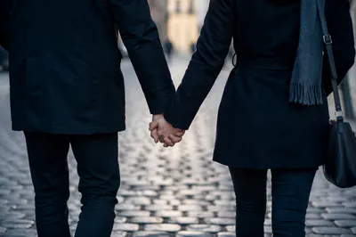 Romantic Couple Holding Hands on Cobblestone Street