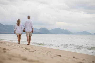 Mature Couple Walking Hand in Hand on Beach