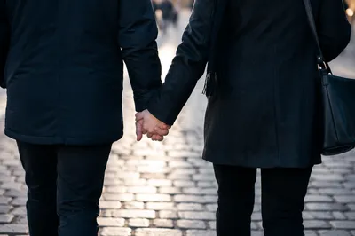Romantic Couple Holding Hands on Cobblestone Street