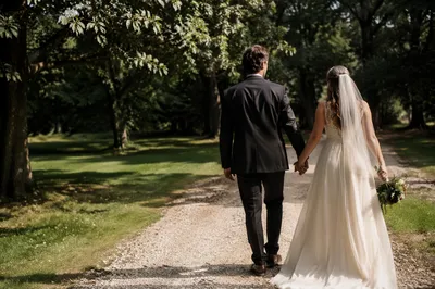 Newlywed Couple Walking Through Leafy Park