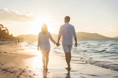 Romantic Couple Walking Along Golden Shoreline