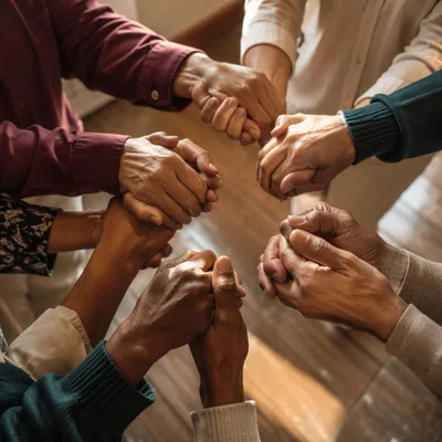 Diverse Adults Joining Hands in Prayer