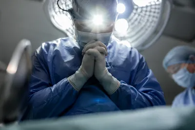 Surgeon Praying Before Surgery in Scrubs