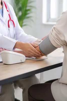 Doctor Taking Blood Pressure in Clinic