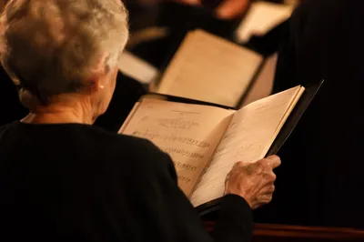 Elderly Choir Member Holding Hymnal on Sunday