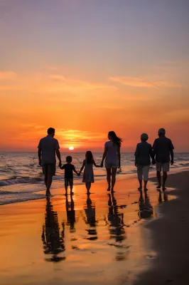 Family Silhouettes Walking on Beach at Sunset