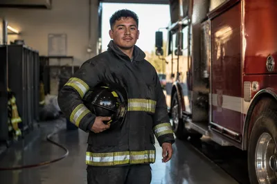 Young Firefighter Beside Fire Engine