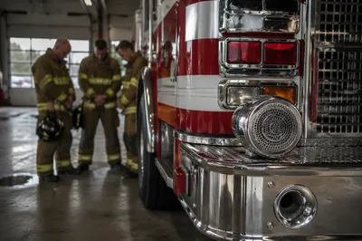Firefighters Praying Beside Engine in Station