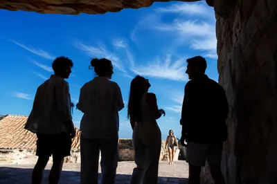 Backlit Friends Laughing Beneath Stone Overhang