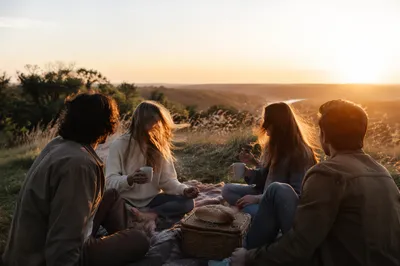 Friends Laughing on Golden Hillside Picnic