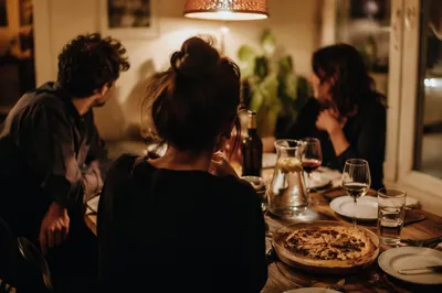 Friends Laughing Around Cozy Dinner Table