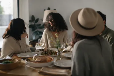Friends Laughing Around Cozy Dinner Table