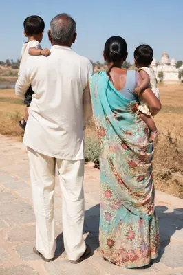 Grandparents Holding Grandchildren in Rural Sunlight