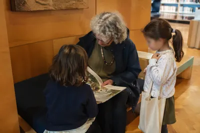 Grandmother Reading With Grandchildren in Library