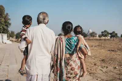 Grandparents Holding Grandchildren in Rural Sunlight