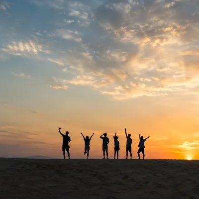 Friends Celebrating Sunset Selfie on Sandy Dune