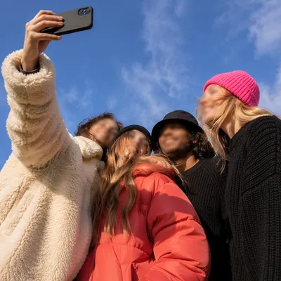 Cheerful Outdoor Group Selfie Under Blue Sky