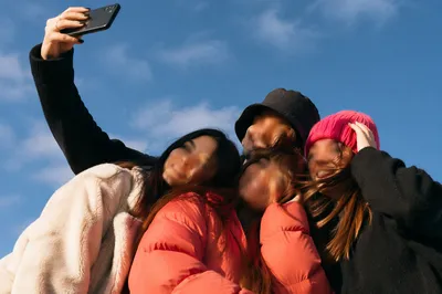 Cheerful Outdoor Group Selfie Under Blue Sky