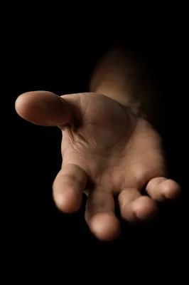 Close-Up Reaching Hand in Dark Studio