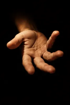 Open Hand Reaching in Dark Background