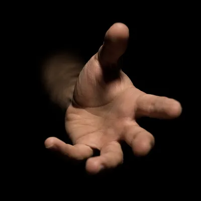 Outstretched Hand Reaching in Dark Studio