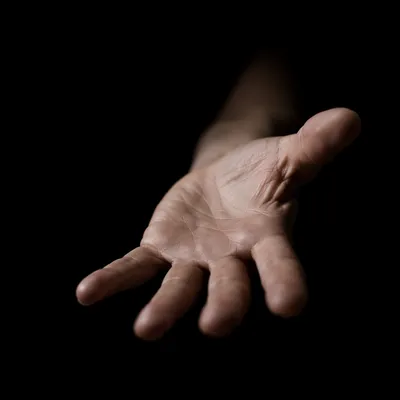 Open Hand Reaching in Dark Studio