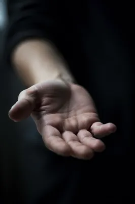 Outstretched Hand Reaching in Quiet Darkness