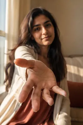 Woman Reaching Hand Toward Camera Indoors