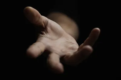Close-Up Hand Reaching in Darkness