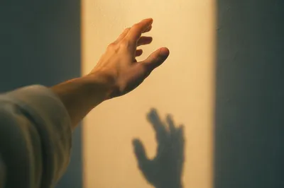 Hand Reaching Toward Warm Light