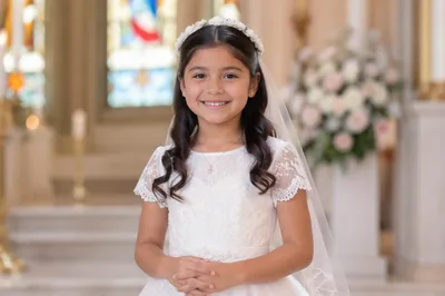 Smiling Child in White Communion Attire