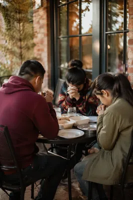 Hispanic Family Praying Before Dinner Outdoors