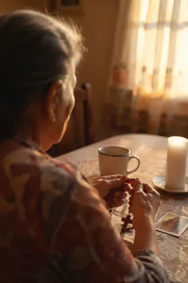 Hispanic Grandmother Praying with Rosary at Dawn