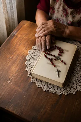 Hispanic Grandmother Rosary Prayer on Wooden Table