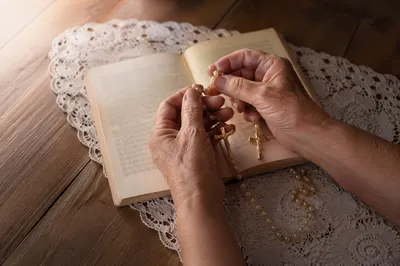 Hispanic Grandmother Hands Holding Rosary in Prayer