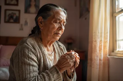 Elderly Hispanic Woman Praying by Window