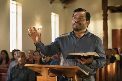 Pastor Preaching in Sunlit Church Interior