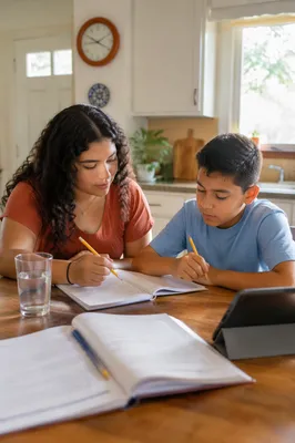 Hispanic Siblings Studying at Kitchen Table