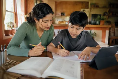 Hispanic Siblings Studying at Kitchen Table