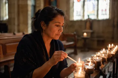 Woman Lighting Prayer Candle in Church