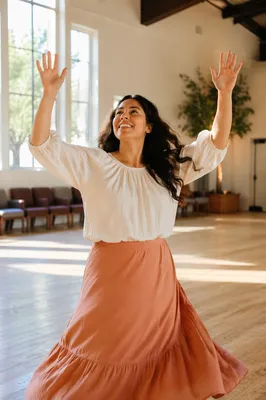 Joyful Woman Dancing in Sunlit Hall