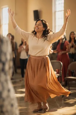 Joyful Woman Dancing in Sunlit Hall