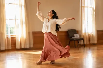 Joyful Woman Dancing in Sunlit Hall