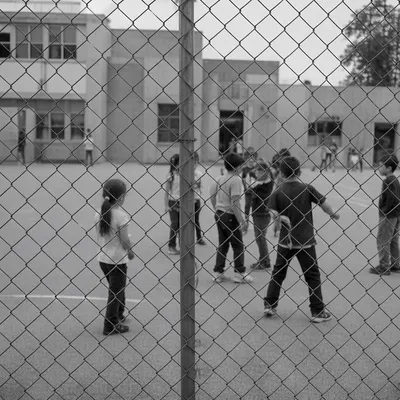 Children Playing Behind School Playground Fence