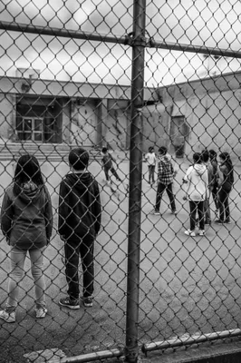 Children Playing Behind School Playground Fence